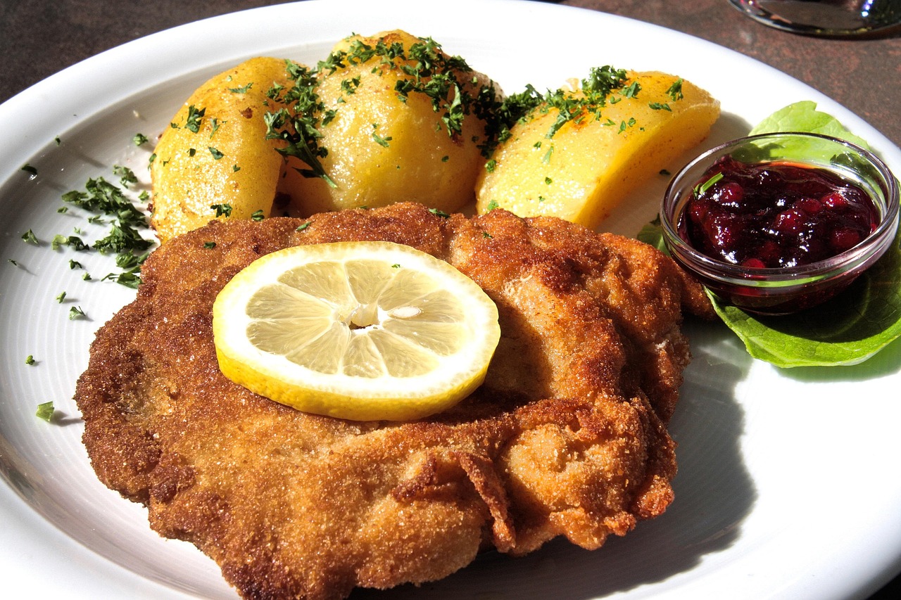 Wiener Schnitzel mit Kartoffeln und Zitrone auf einem Teller